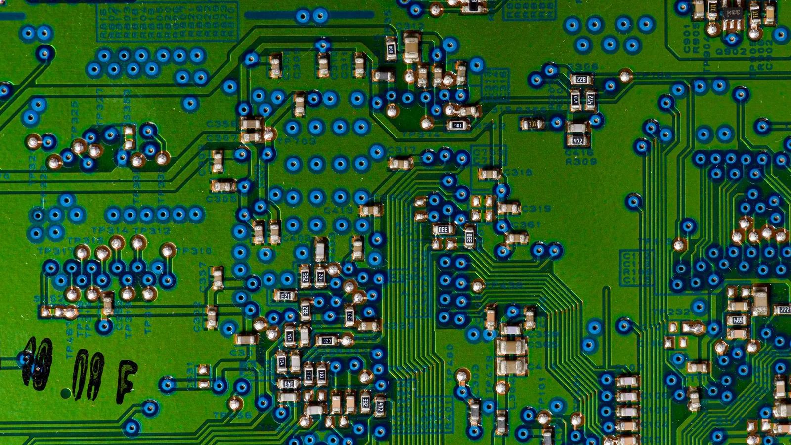 Top-down view of a green circuit board with small components and traces