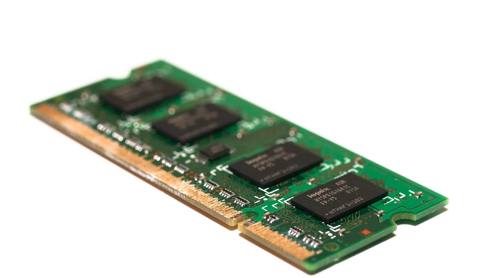 A green memory module photographed on a white background