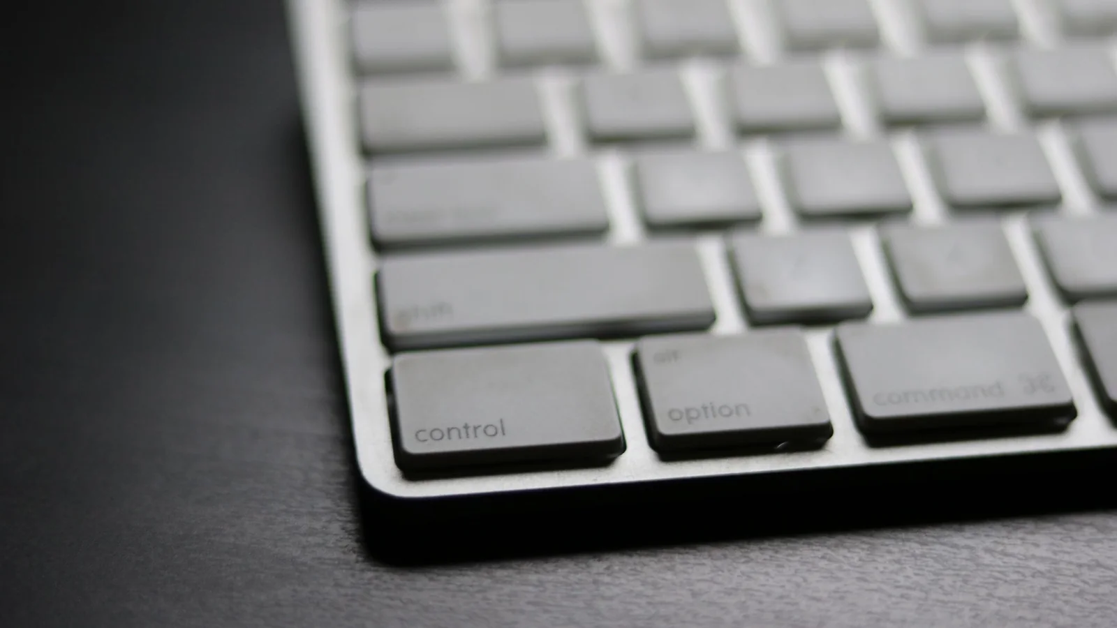 Close-up of a slim white and silver computer keyboard in soft light